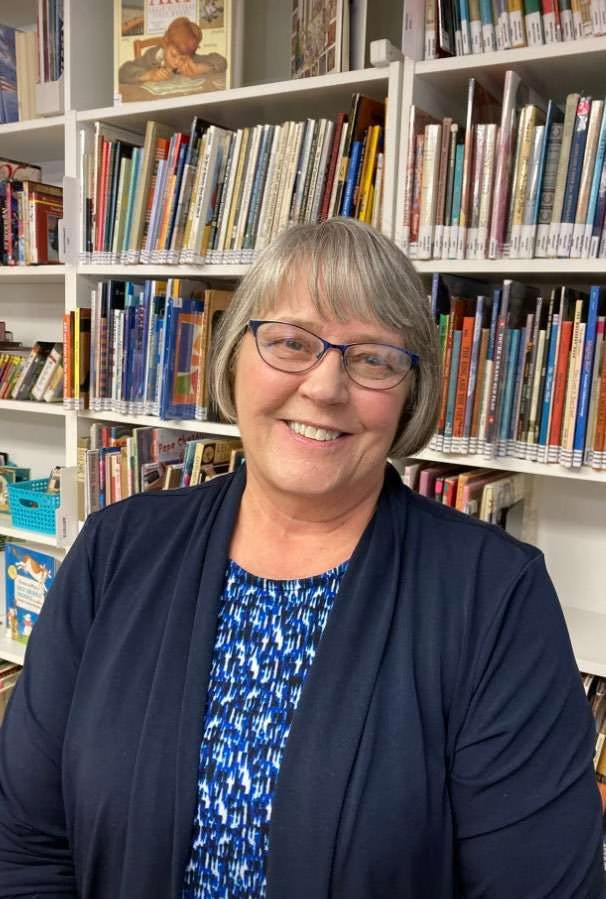 Sandy Hall, founder and curator of Hall's Living Library, standing in the library